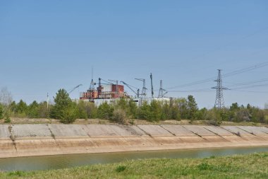 Ukrayna 'nın Çernobil Yasak Bölgesi' nde çekilen vinç ve elektrik hatlı Çernobil Nükleer Santrali görüntüsü.