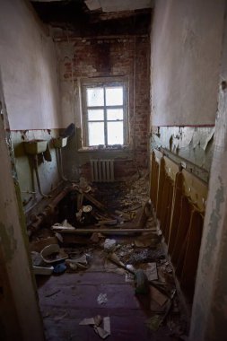 Dağınık kağıtlar, kırık mobilyalar ve Çernobil Yasaklama Bölgesi, Pripyat, Ukrayna 'da yakalanan küçük bir yapay ağaç ile çürüyen sınıf..