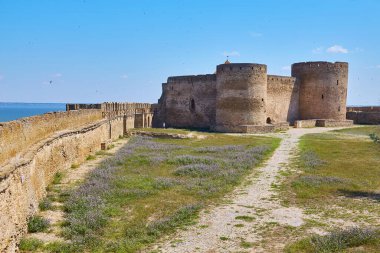 Akkerman Kalesi 'nin (Bilhorod-Dnistrovskyi Kalesi) iç avlusunun temiz mavi gökyüzünün altındaki taş kulelerini ve duvarlarını gösteren görüntüsü.