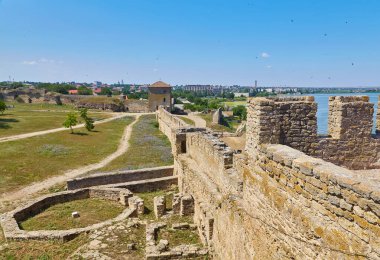 Akkerman Kalesi 'nin (Bilhorod-Dnistrovskyi Kalesi) iç avlusunun temiz mavi gökyüzünün altındaki taş kulelerini ve duvarlarını gösteren görüntüsü.