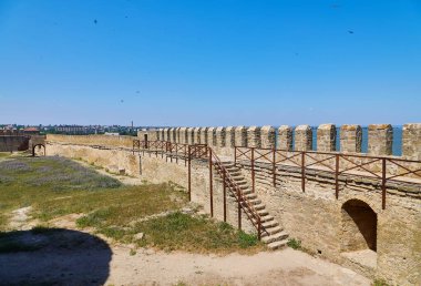 Akkerman Kalesi 'nin (Bilhorod-Dnistrovskyi Kalesi) iç avlusunun temiz mavi gökyüzünün altındaki taş kulelerini ve duvarlarını gösteren görüntüsü.