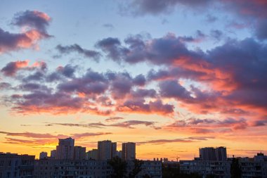 Canlı bir şehir silueti dramatik bir günbatımı gökyüzüne karşı renkli bulutlarla, dinamik ve kentsel bir arkaplan için mükemmel..