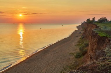 Güneş, sakin ve uçsuz bucaksız bir okyanusun üzerinde yükseliyor. Renkli ve sakin bir deniz manzarası yaratıyor..
