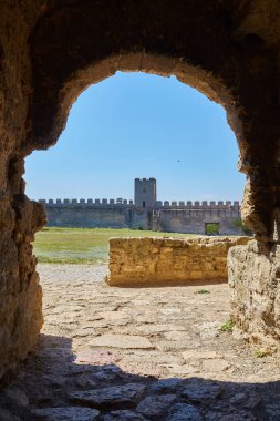 Akkerman Kalesi 'nin (Bilhorod-Dnistrovskyi Kalesi) taş kemerli bir kemer boyunca, kale duvarlarını, bir kuleyi ve avluyu gösteren manzarası.
