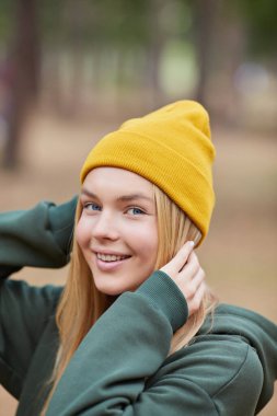 Sonbaharda parkta örülmüş bereli muhteşem sarışın beyaz bir kadının yakın plan portresi. Genç kadın vesikalığı, doğal ışık, rötuşlu, canlı renkler..