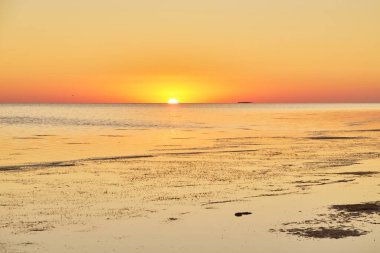 Geniş, sakin tuz gölü alacakaranlıkta gökyüzünün pembe ve mavi tonlarını yansıtıyor..