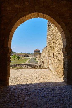 Akkerman Kalesi 'nin (Bilhorod-Dnistrovskyi Kalesi) taş kemerli bir kemer boyunca, kale duvarlarını, bir kuleyi ve avluyu gösteren manzarası.