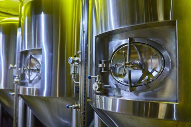 Bira fabrikasındaki büyük, paslanmaz çelik tanklar..