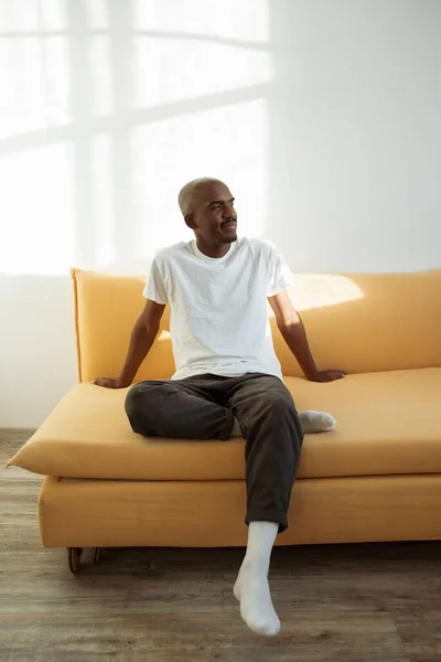 Junger Schwarzer Mann Entspannt Sich Hause Auf Der Gelben Couch Stockbild