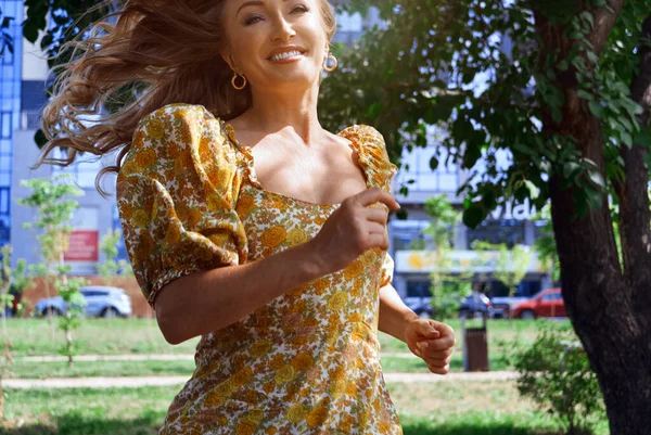 快乐的金发女人在城市街道上奔跑 — 图库照片
