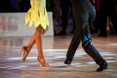 Çift Latin dansı yapıyor. Dans eden bir çiftin bacakları.