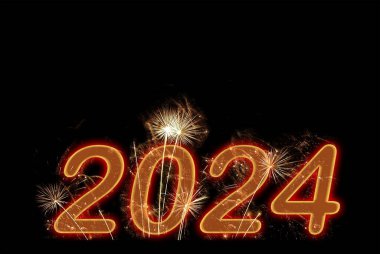 2024 yılbaşı kırmızı havai fişekleri kara gökyüzü arka planında. Yeni yıl kutlaması