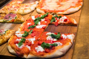 Restorandaki ahşap masada bir sürü pizza dilimi var.