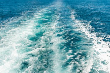 Mavi denizdeki sürat teknesinden dalga izleri.