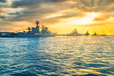 Askeri donanma gemileri gün batımında deniz koyunda savaş gemileri.