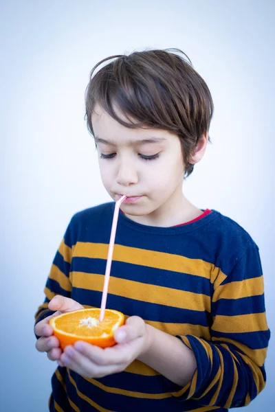オレンジからジュースを取る小さなかわいい少年 — ストック写真