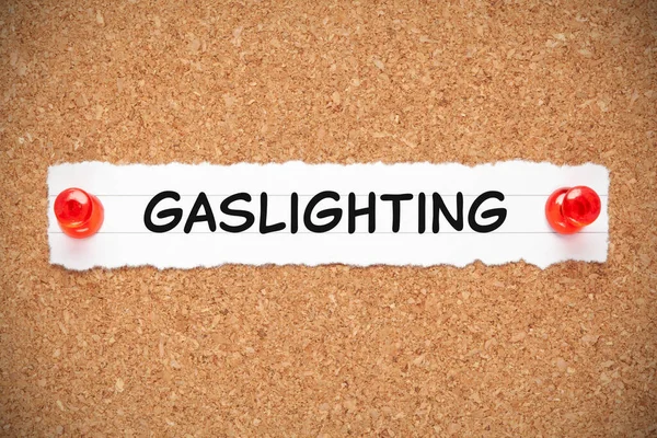 Słowo Gaslighting Ręcznie Napisane Białym Papierze Przypiętym Tablicy Ogłoszeń Korkowych — Zdjęcie stockowe