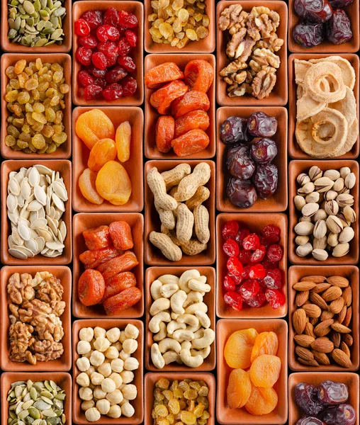 Seamless flat lay food background of dehydrated fruits, seeds and nuts on black. Non-perishable antioxidant gluten free foods concept