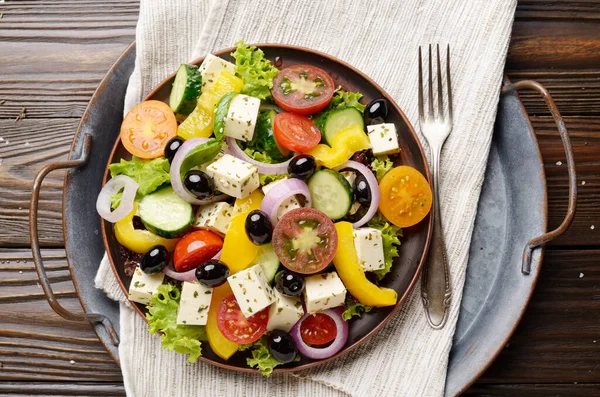 Top view at Mediterranean diet dish greek salad on vintage metal tray
