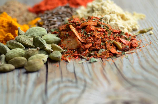 Assorted spices and dry herbs on wooden background