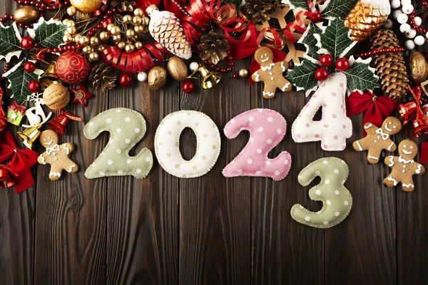 木制桌子上摆放着色彩艳丽 针织数字2024的印有圣诞装饰平面图案的Polkadot面料 免版税图库照片