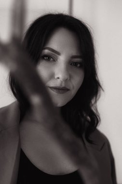 Şık bir kızın moda portresi. Stüdyoda günlük kıyafetlerle poz veren güzel model Avrupalı bir kız. Kadın vücudu ve tarz kavramı. Siyah beyaz fotoğraf