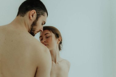 Cheerful woman and man standing on white background, isolated. Concept of natural beauty and feeling comfortable. Body positive young couple.