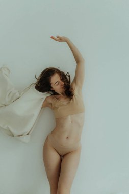 Cheerful woman standing on white background. Nude makeup, perfect skin, long hair. White background. No focus blurred and noise effect