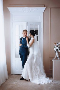 Gelin ve damat, güzel genç bir çift. Şatafatlı bir iç mekan. Düğün günü konsepti