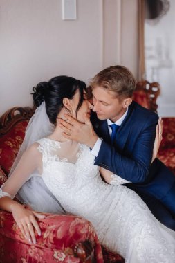 Gelin ve damat, güzel genç bir çift. Şatafatlı bir iç mekan. Düğün günü konsepti