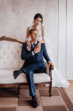 Gelin ve damat, güzel genç bir çift. Şatafatlı bir iç mekan. Düğün günü konsepti