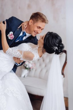 Gelin ve damat, güzel genç bir çift. Şatafatlı bir iç mekan. Düğün günü konsepti