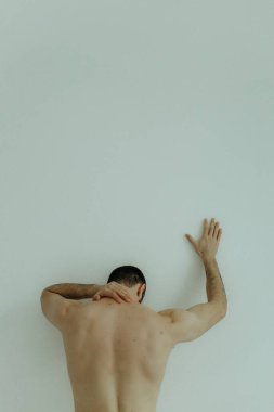 People, healthcare and problem concept - man suffering from back pain or reins. Close up hands touching back pain. Man standing on white background. No focus blurred and noise effect.