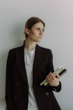 Smart girl with a notepad in her hands, on a white background with space for text. Coaching and tutor concept