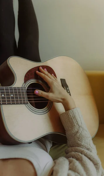 Creative hobby. Talented young female musician sit in armchair alone compose instrumental song using classic guitar. Smiling lady play calm melody on musical instrument. Copy space