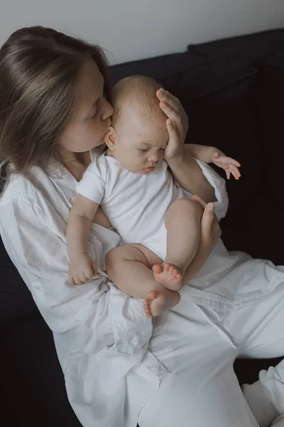 ベッドで赤ちゃんと遊んでいる若い女性のサイドビュー 幸せな母親と新生児のケアの概念 — ストック写真