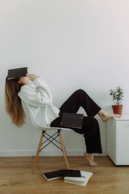 Elinde not defteri olan zeki, yorgun bir kız. Beyaz bir arka planda, mesaj için yeri var. Beyin fırtınası konsepti ve planlama. Metin için yeri olan fotoğraf