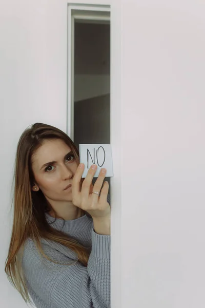 Young beautiful blonde woman with a sign Yes and No. Choice and question answer concept, the choice yes or no. Photo with place for text