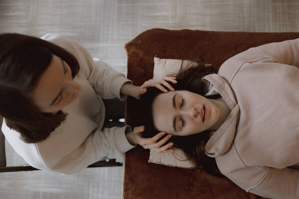 Массаж женской энергии расслабляющий и уход за телом и внимательное здоровье нежные женские руки, держащие голову, делая перекладины доступа и лицо молодой процедуры. Энергетический массаж возобновляет циркуляцию энергии в организме.