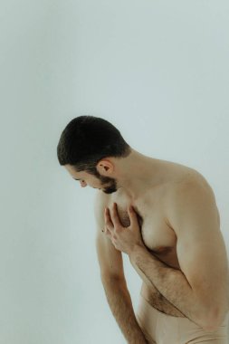 People, healthcare and problem concept - man suffering from back pain or reins. Close up hands touching back pain. Man standing on white background. No focus blurred and noise effect.