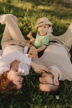 Genç bir aile için yaz güneşli bir gün, baba, anne ve küçük oğlu neşeli ve mutlu oldular. Mutlu aile konsepti fotoğrafı. Odak bulanıklığı ve gürültü efekti yok