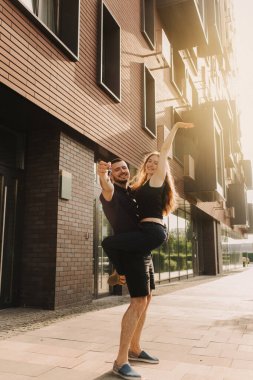 Heyecanlı genç eşlerin ev sahiplerinin tuttuğu anahtarlara odaklan. Mutlu evli çift yeni eve taşınmayı kutluyor, anahtarları gösteriyor, apartmanda duruyor, gayrimenkul ipoteği konsepti....