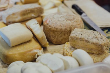 Elle doldurulmuş rulo ve peynir parçaları. Sokak yemeklerinde ahşap kesim tahtasında lezzetli hamur işleri ve parşömen kağıdı. Yumuşak odak bulanık ve gürültü efekti.