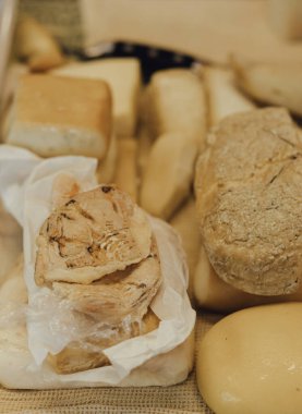 Elle doldurulmuş rulo ve peynir parçaları. Sokak yemeklerinde ahşap kesim tahtasında lezzetli hamur işleri ve parşömen kağıdı. Yumuşak odak bulanık ve gürültü efekti.