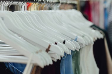 Perakende mağazasındaki metal askılarda farklı renklerde moda gömleği seçimi. Geri Dönüşüm Konseptini Azalt. Yatay fotoğraf.