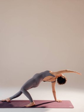 Genç hamile kadın yoga egzersizleri yapıyor ve stüdyoda meditasyon yapıyor. Sağlık, farkındalık, rahatlama ve sağIık kavramı.