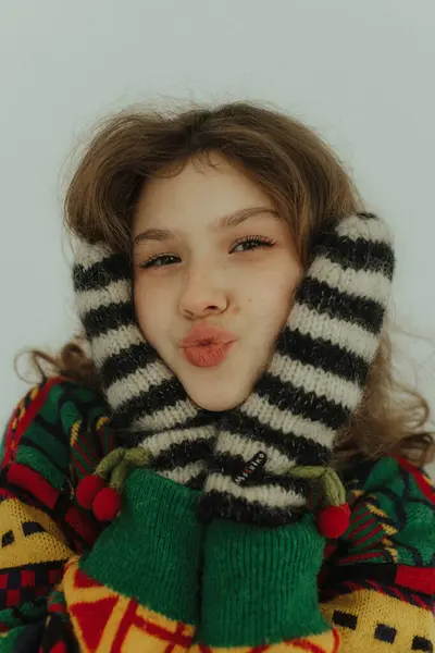 Örgü süveter ve sıcak eldivenlerle gülümseyen neşeli genç kız. Neşeli gülümseyen genç bir kadın Noel tatiline hazırlanıyor. Seçici odak.