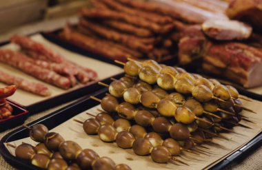 El yapımı füme et ürünleri. Sokak yemek fuarında et, salam ve sosis sergileriz. Yumuşak odak bulanık ve gürültü etkisi. Lezzetli Konsept.