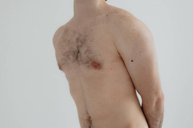 People, healthcare and problem concept - man suffering from back pain or reins. Close up hands touching back pain. Man standing on white background. No focus blurred and noise effect.