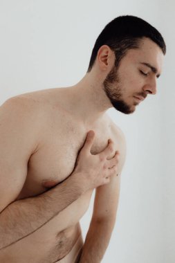 İnsanlar, sağlık hizmetleri ve sorun kavramı. Acı çeken ya da dizginlenen bir adam. Acıya dokunarak ellerini kapat. Beyaz arka planda duran adam. Odak bulanıklığı ve gürültü efekti yok.